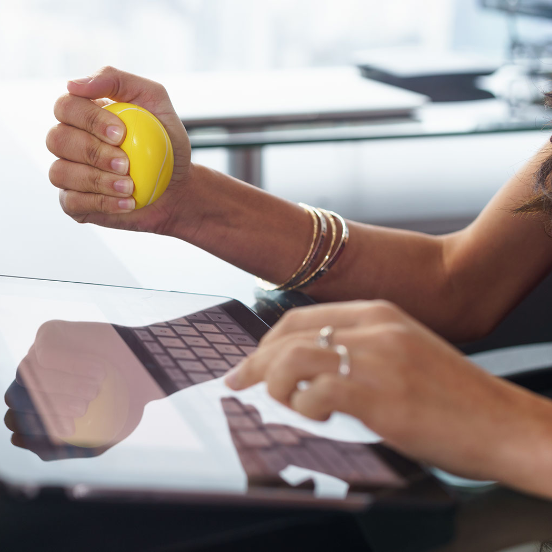 marketer for lawfirm typing on tablet and using yellow stress ball